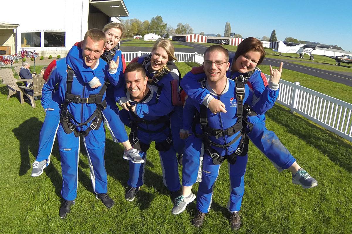 Six young tandem students wearing all blue exited to tandem skydive.