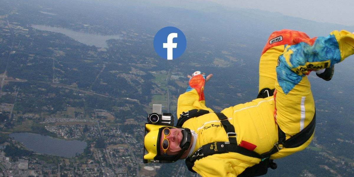 Male in yellow skydiving gear looking at camera and smiling during free fall