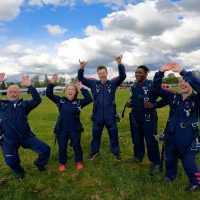 a group of skydivers celebrating a successful jump