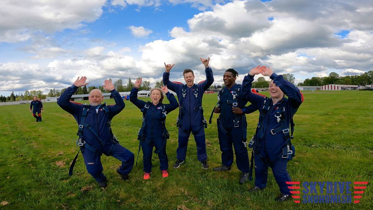 a group of skydivers celebrating a successful jump