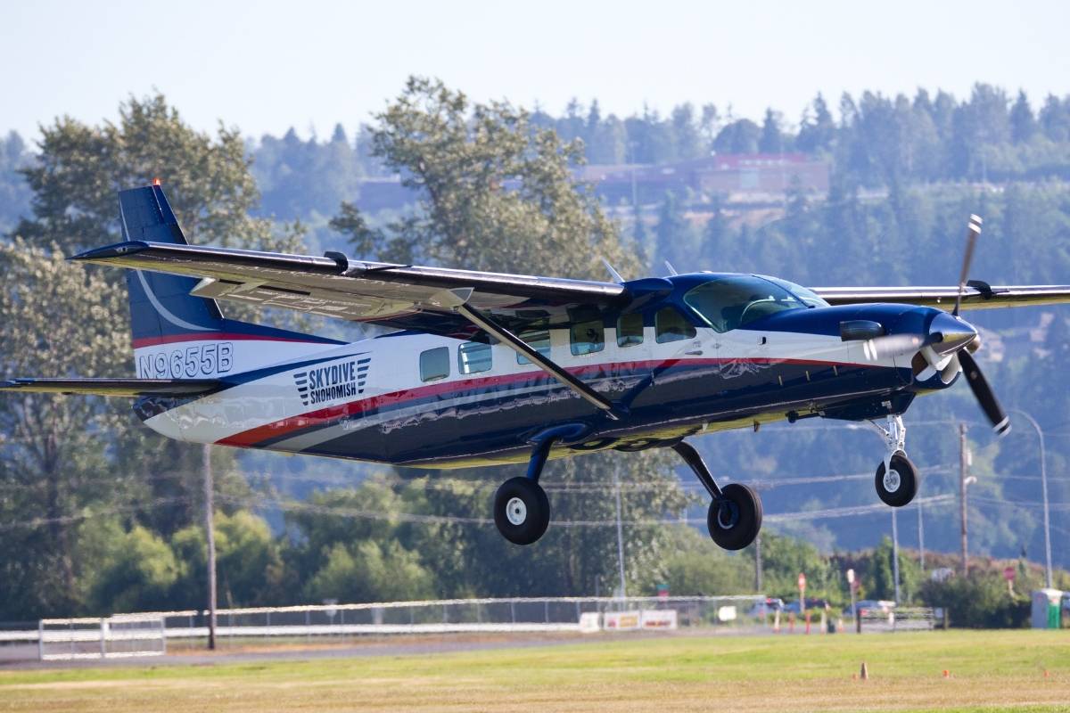 Blue, White, and Red Skydive Snohomish airplane coming down to land.