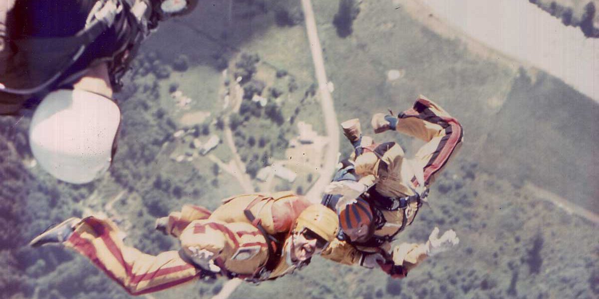 Two experienced skydivers in free fall wearing orange