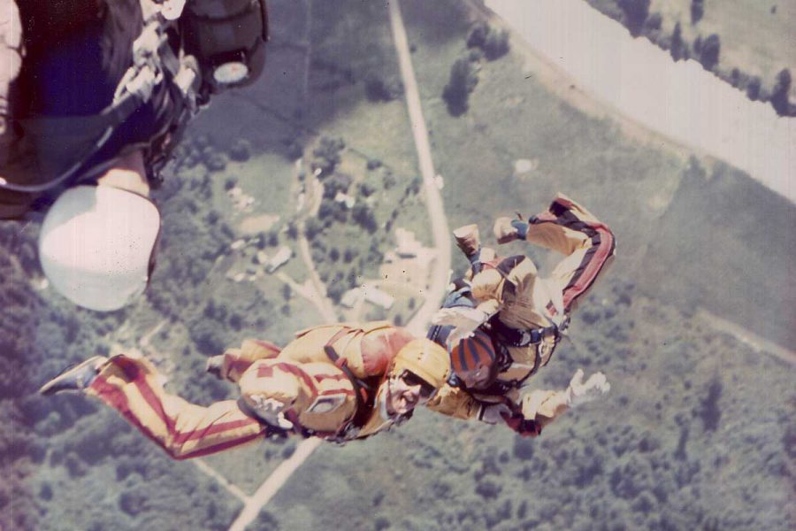 Two experienced skydivers in free fall wearing orange