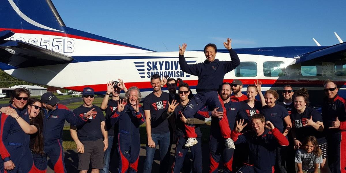 Skydive Snohomish staff posing in front of Red, White, and Blue airplane.