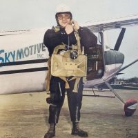 Gentlemen buckling helmet and getting prepared to get on White and Black airplane