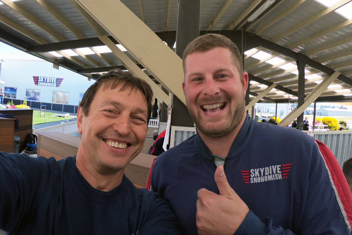 Tandem instructor and student smiling in the waiting area of Skydive Snohomish.